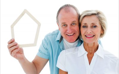 Happy senior couple holding a house outline